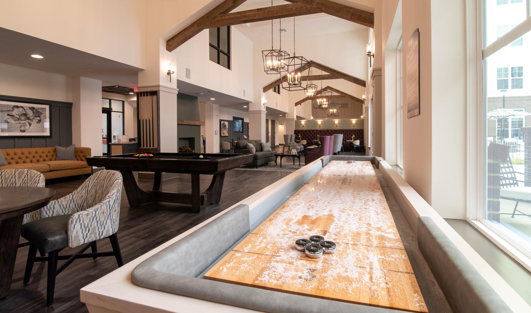 a large room with a pool table and chairs