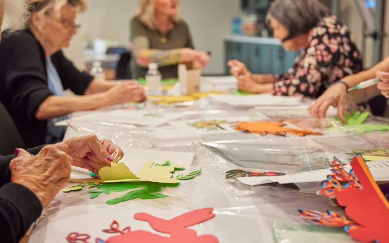 residents sitting at a table doing crafts