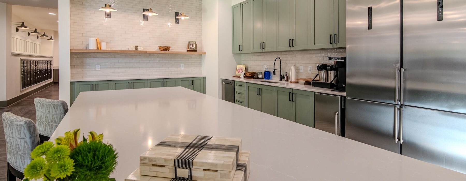 resident kitchen with green cabinets and stainless steel appliances